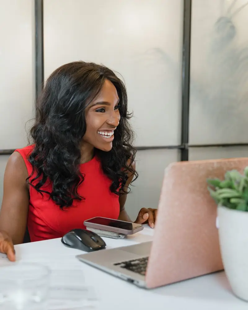 WordPress SEO company client: a business owner smiling at her laptop